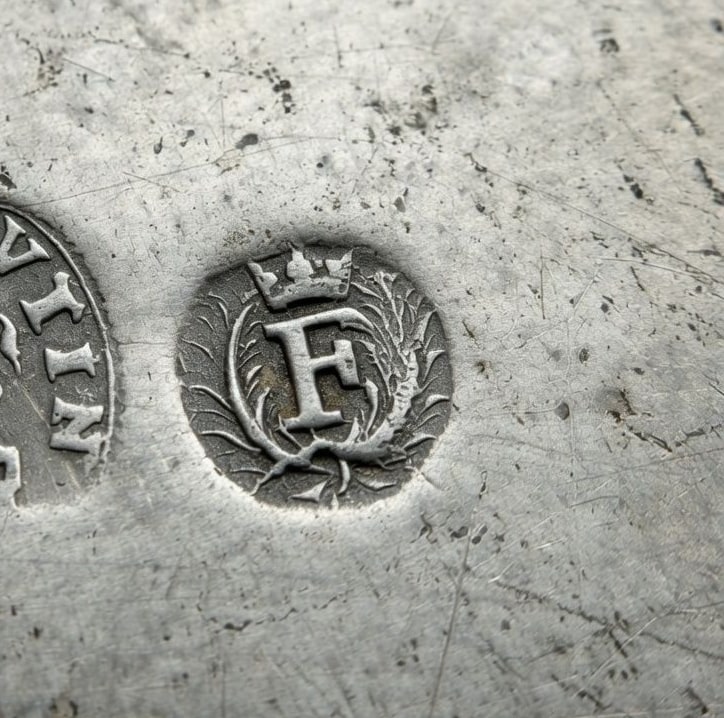 Close crop of the crowned F quality mark in a laurel wreath